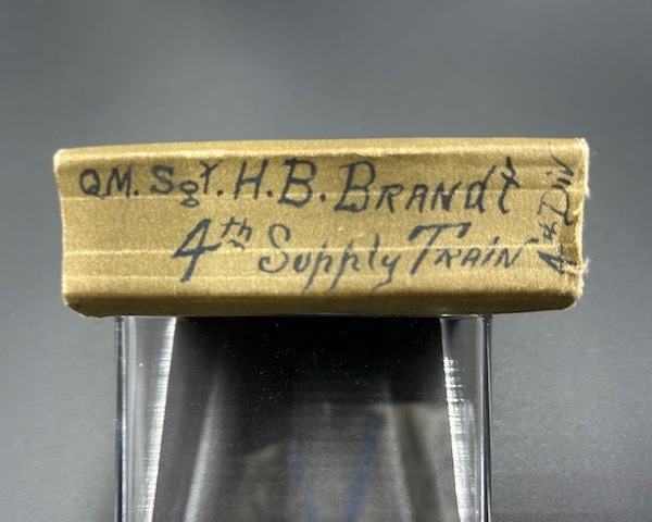 QM Sergeant Brandt's rank, name, and unit written on the spine of the dictionary.