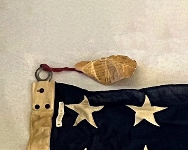 The tag is tied to the flag with the ribbon tied and sealed to the tag.