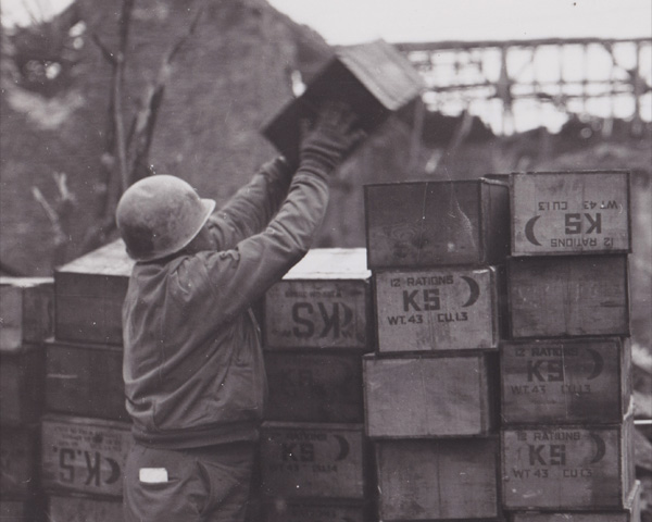 K-ration crates are stacked for distribution.