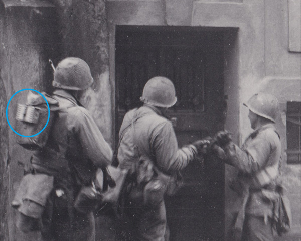 Soldier carries a K-ration box on the outside of his pack for quick access.