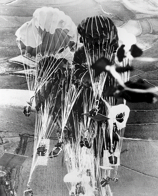 Several airdroped supplies shown parachuting to the ground.
