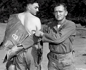 Lt. Brigg points to a bruise on Lt Bassett, made by hand grenade fragments.