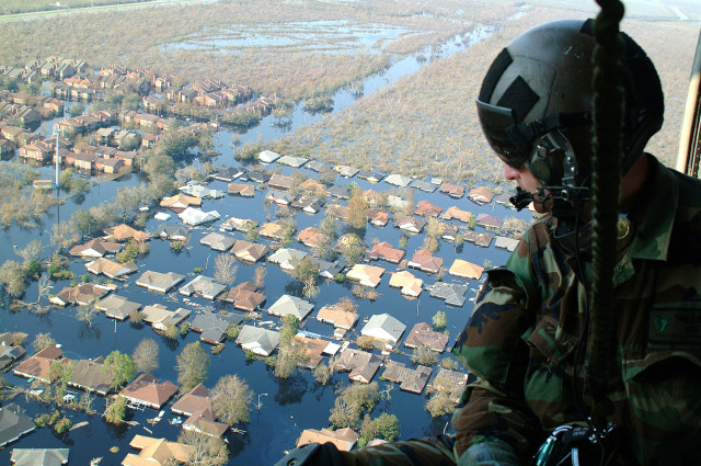 Soldier is assessing hurricane damage from a helicopter.