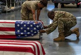 Mortuary Affairs Soldiers attaching the US flag to the “Honor” cover.