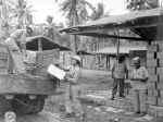 Soliders loading supplies in the back of a truck.