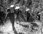 Soldiers carring supplies up a hill.