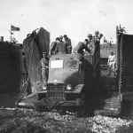 Several Soldiers traveling in the back end of a truck.