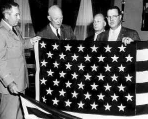 Quartermaster General MG Andrew T. McNamara and President Eisenhower examine new 49 star flag.